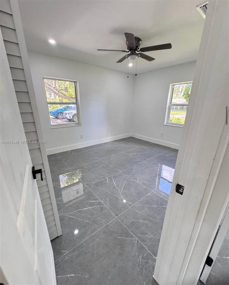 A bedroom with gray marble-look tile flooring, white walls, and a ceiling fan — 9934 SW 195th St, Cutler Bay FL 33157, CUTLER BAY, FL