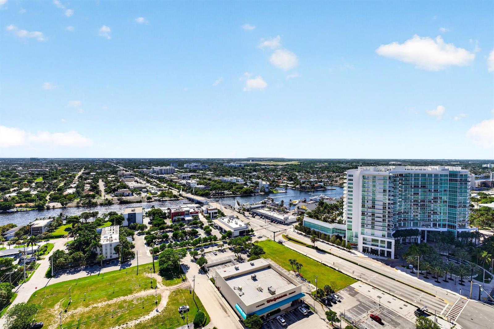 An aerial view shows a Walgreens store, a high-rise building, and a waterway — 111 Briny Avenue # 2711, Pompano Beach FL 33062, POMPANO BEACH, FL