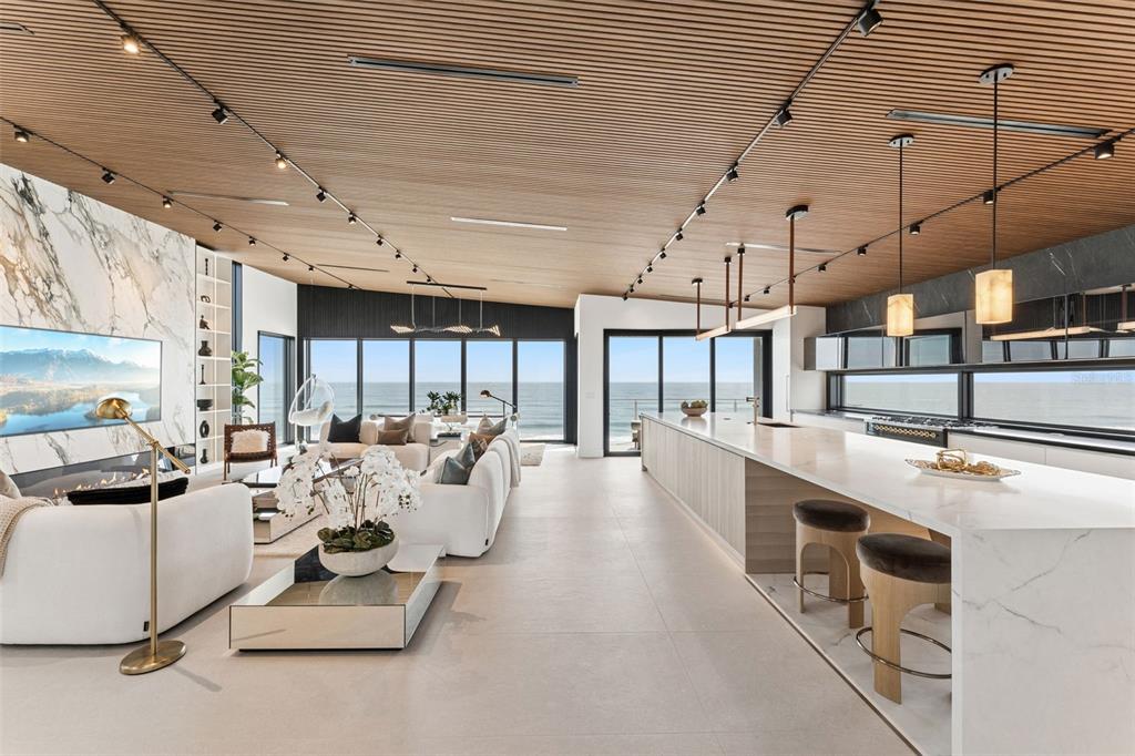 A modern open-concept living room and kitchen feature a slatted wood ceiling and ocean views — 6887 S ATLANTIC AVENUE, NEW SMYRNA BEACH, FL