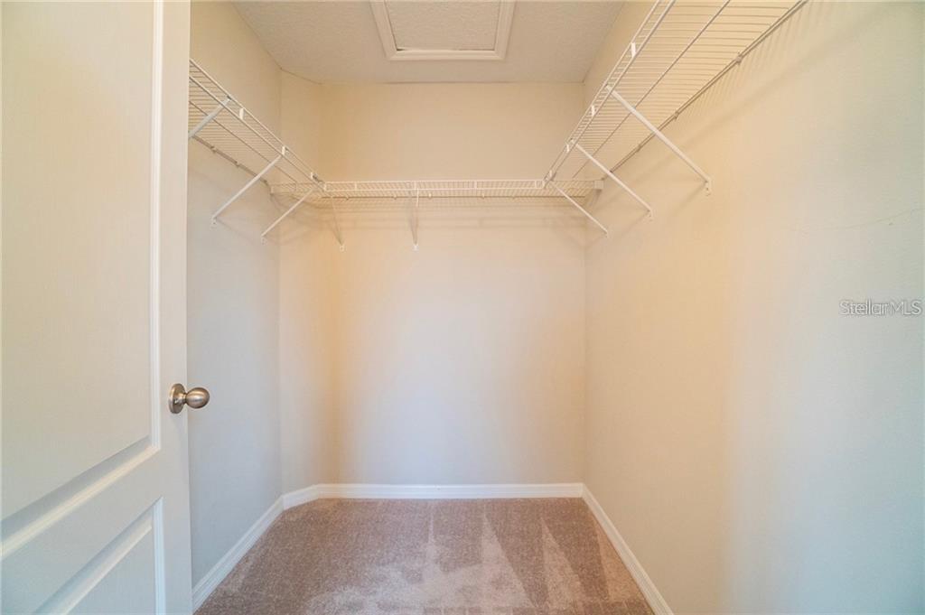 A walk-in closet features beige carpet, light-colored walls, and white wire shelving — 3595 SANCTUARY DRIVE, ST CLOUD, FL