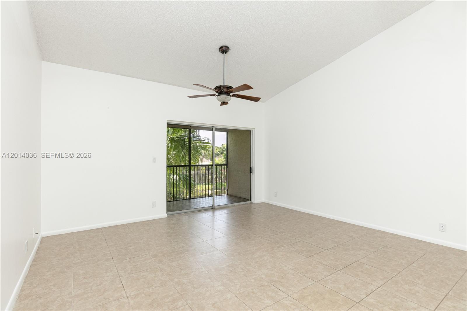 An empty room with white walls, tile flooring, a ceiling fan, and a sliding glass door — 717 Gardens Dr # 201, Pompano Beach FL 33069, POMPANO BEACH, FL