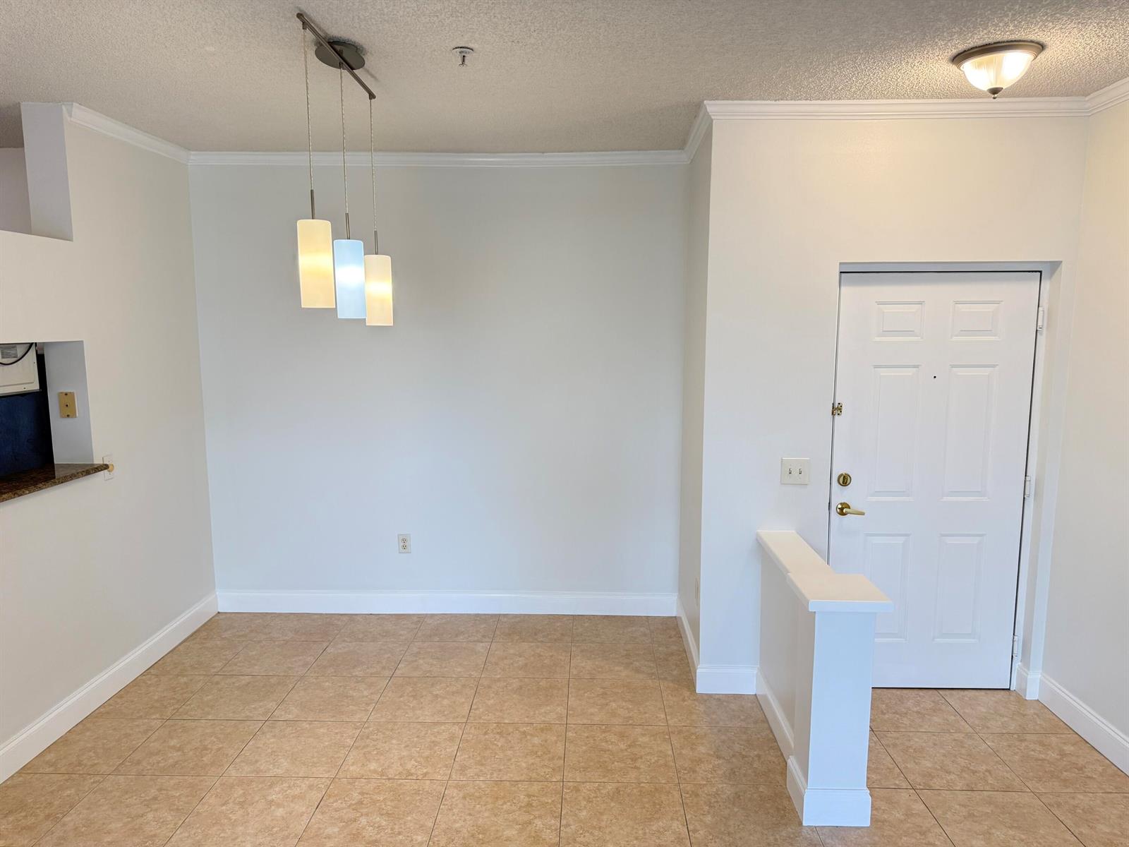 An empty dining area features tan tile flooring, a three-light pendant fixture, and white walls — 1407 Tuscany Way # 1407, Boynton Beach FL 33435, BOYNTON BEACH, FL