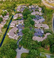 An aerial view shows a residential apartment complex surrounded by trees and a canal — 7828 HARDWICK DRIVE UNIT 927, NEW PORT RICHEY, FL