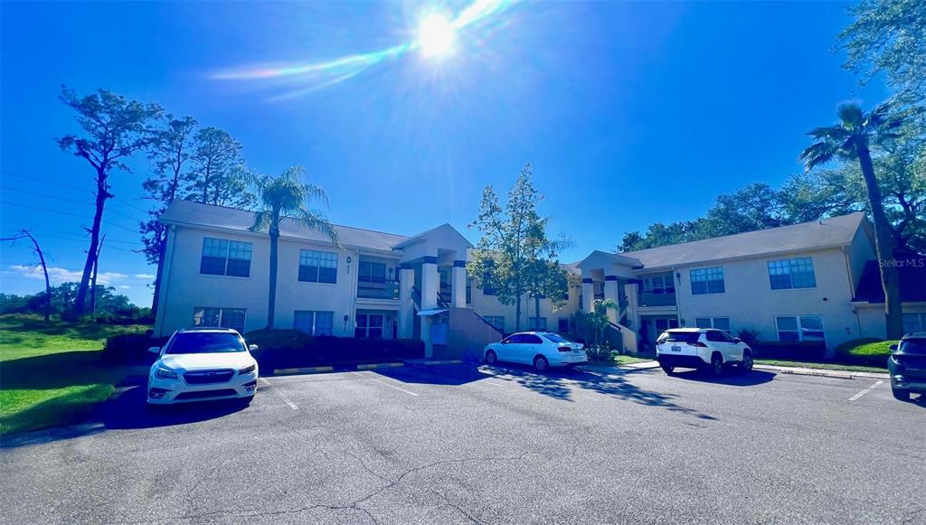 A two-story apartment building with a parking lot in front under a clear sky — 7828 HARDWICK DRIVE UNIT 927, NEW PORT RICHEY, FL