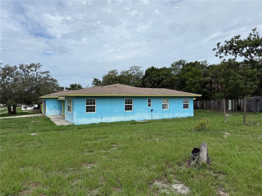A bright blue, single-story house with a hip roof sits on a grassy lot — 6093 ASHLAND DRIVE, SPRING HILL, FL