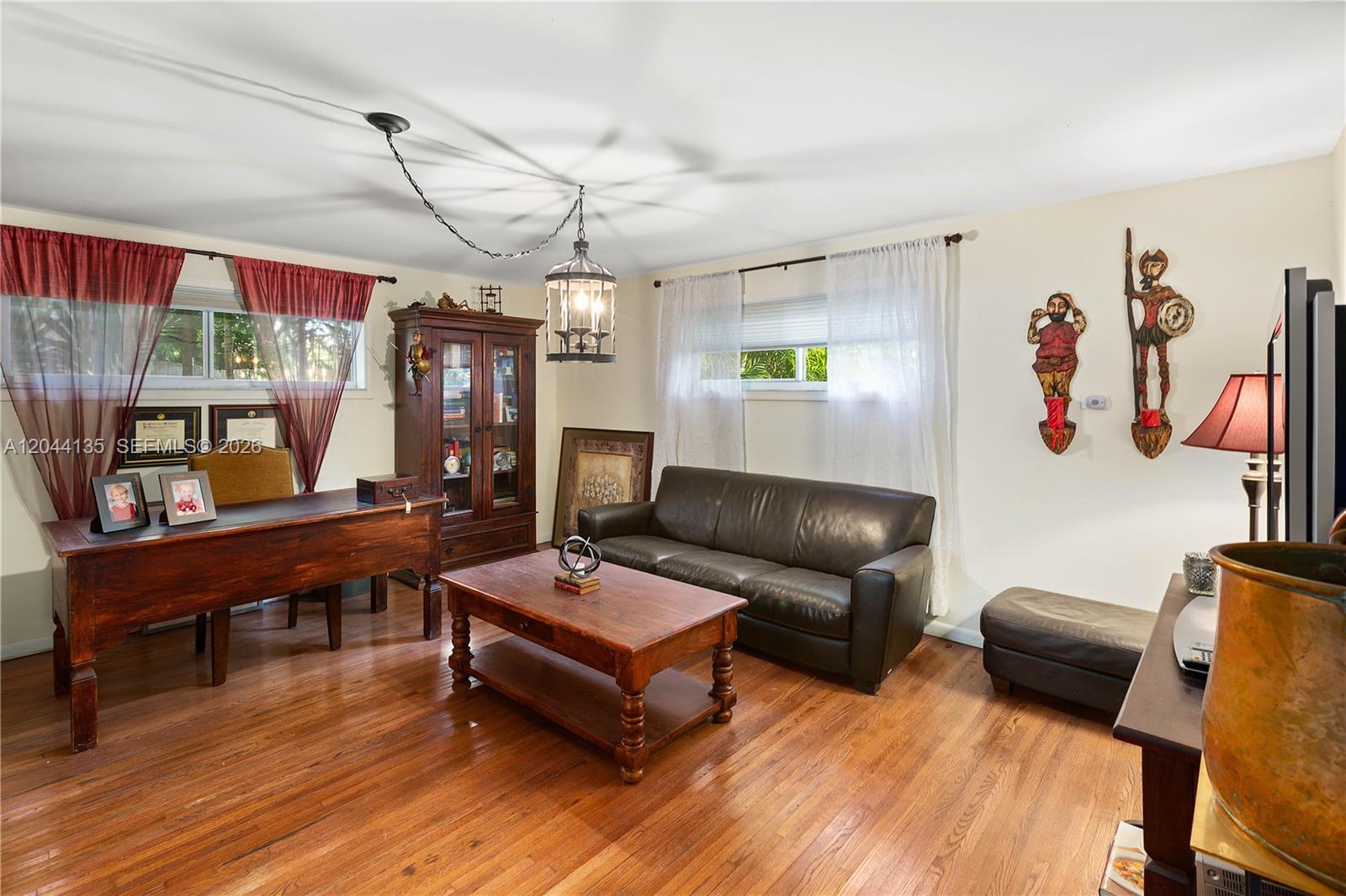 A living room features a leather sofa, wooden coffee table, desk, and hardwood floors — 6315 Maynada St, Coral Gables FL 33146, CORAL GABLES, FL