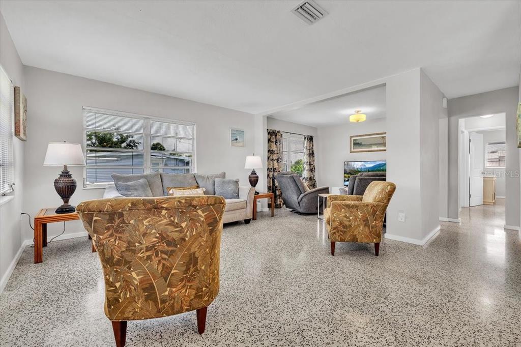 A living room features light gray walls, a speckled floor, and several pieces of furniture — 3414 ASH STREET, PUNTA GORDA, FL