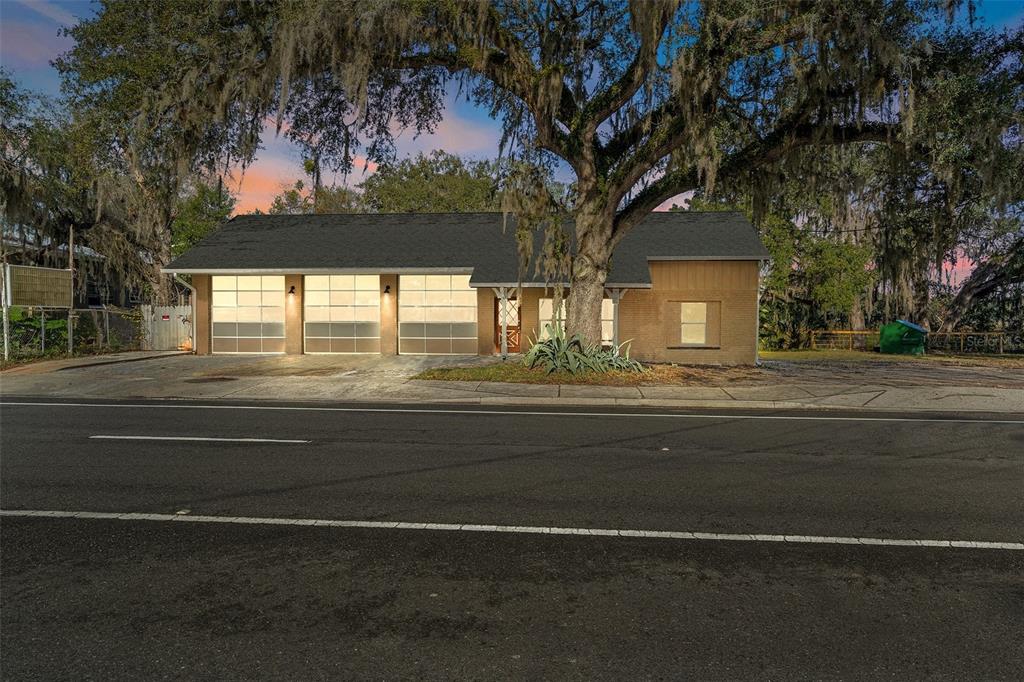 A single-story building with three garage doors and a large oak tree in front — 8929 E GULF TO LAKE HIGHWAY, INVERNESS, FL