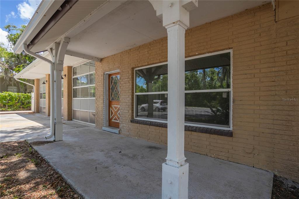 A tan brick building features a covered concrete porch with white support columns and windows — 8929 E GULF TO LAKE HIGHWAY, INVERNESS, FL