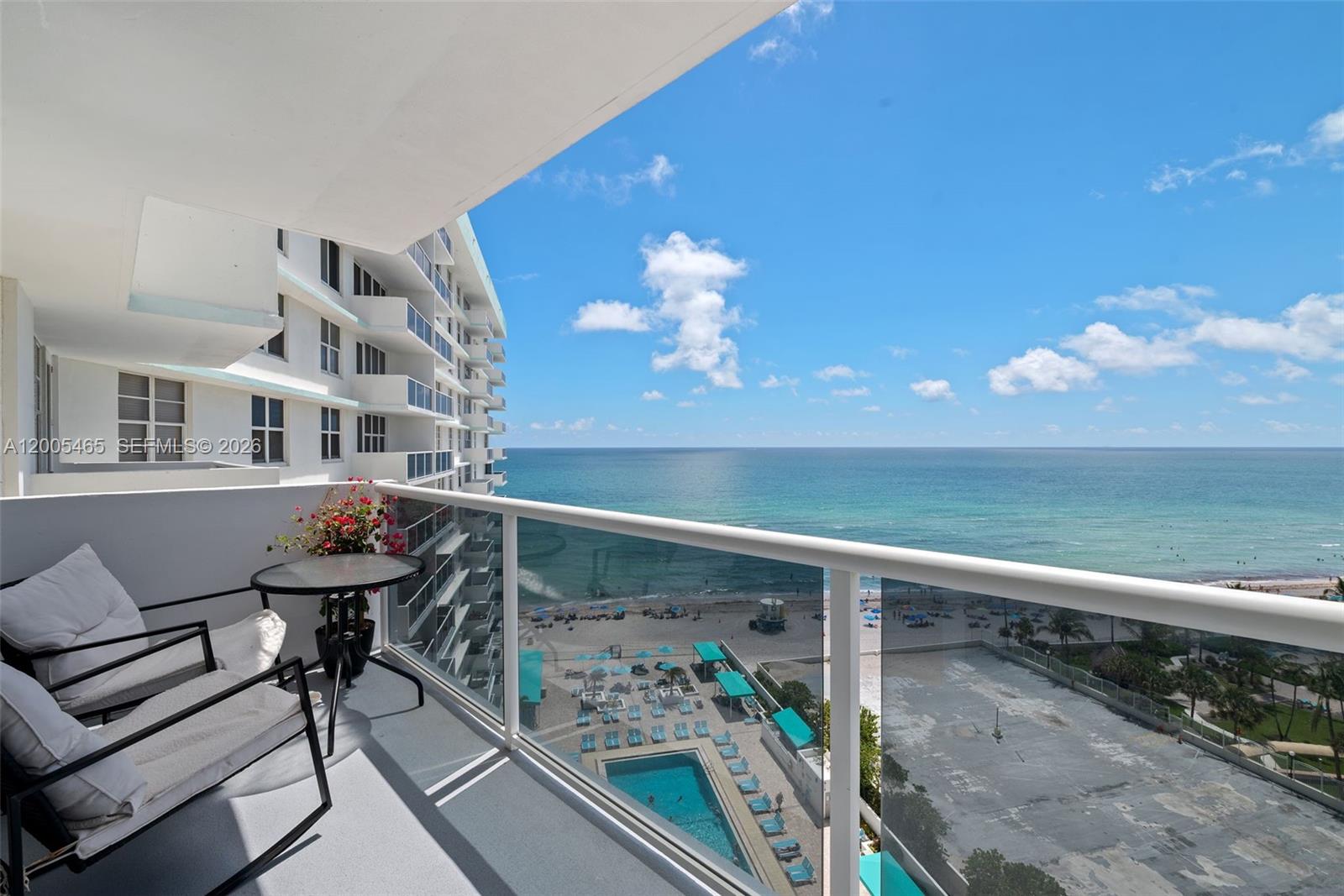 A balcony with patio furniture overlooks a swimming pool, beach, and the ocean — 3725 S Ocean Dr # 1212, Hollywood FL 33019, HOLLYWOOD, FL