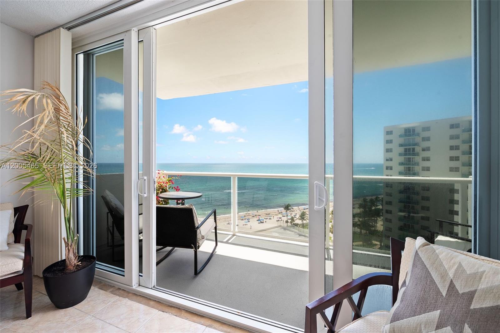 A balcony with ocean views is visible through large sliding glass doors from an interior room — 3725 S Ocean Dr # 1212, Hollywood FL 33019, HOLLYWOOD, FL