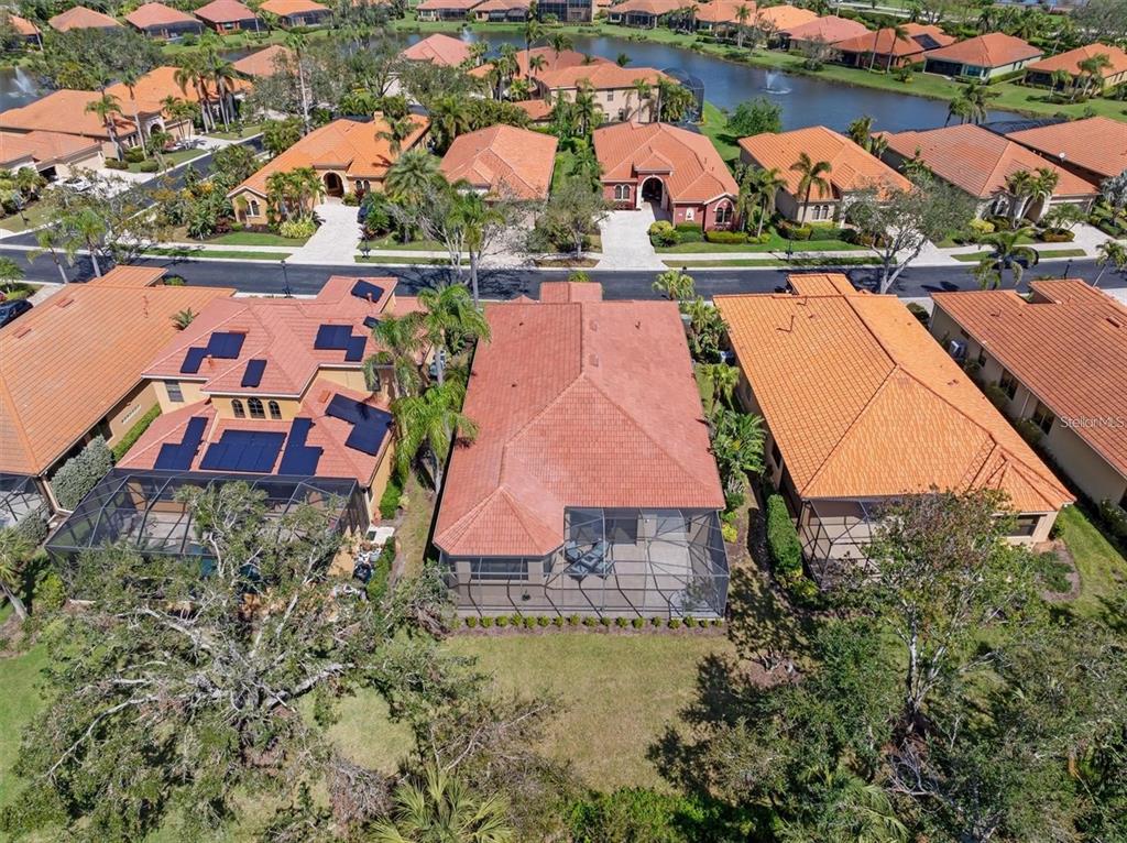 An aerial view shows a residential neighborhood with houses featuring orange tile roofs — 5142 COTE DU RHONE WAY, SARASOTA, FL
