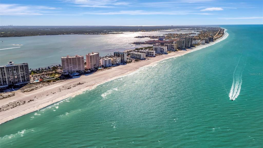 An aerial view of a sandy beach lined with high-rise condominiums along the ocean — 1310 GULF BOULEVARD UNIT 10B, CLEARWATER BEACH, FL