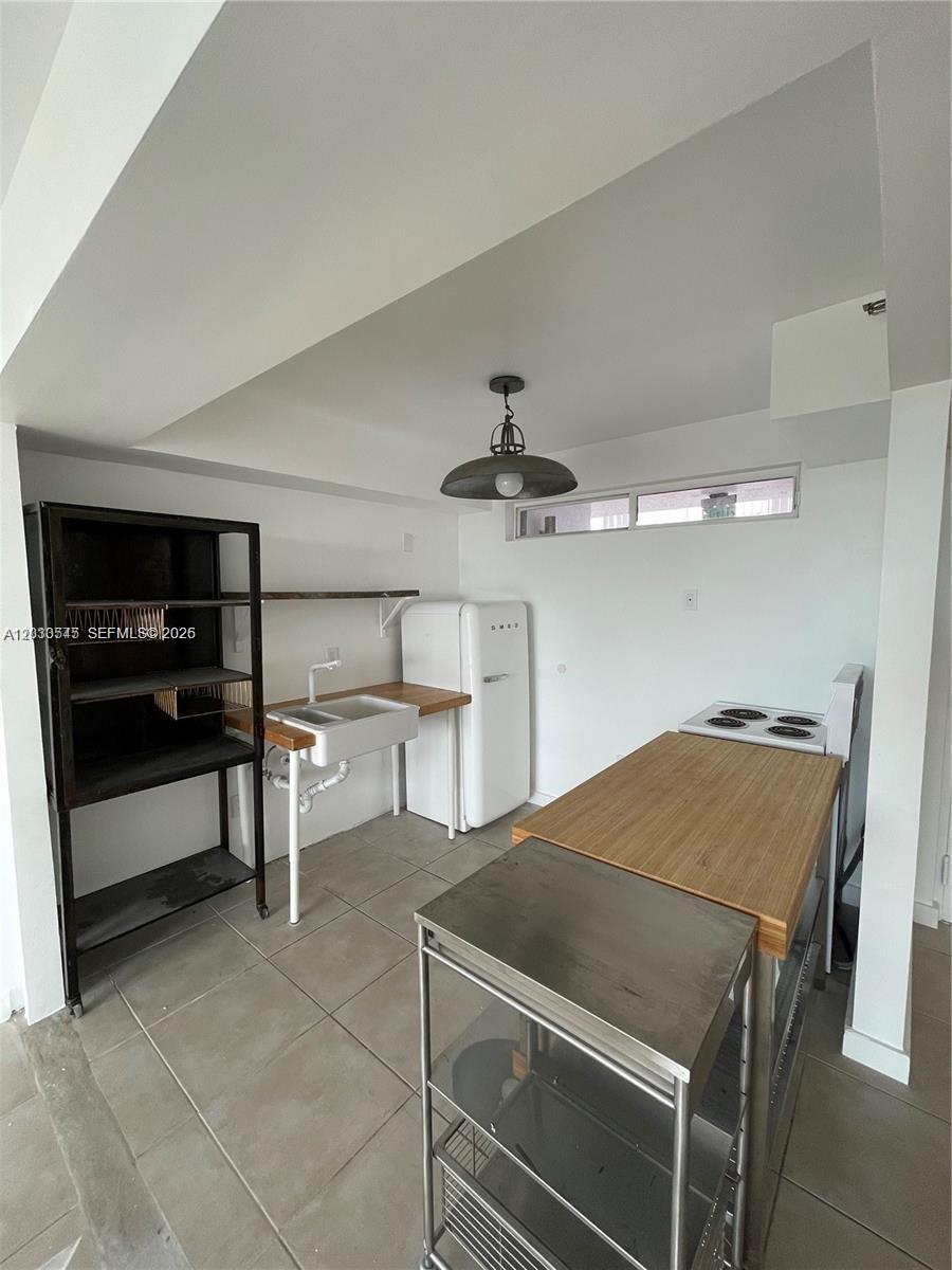 A small kitchen features a white farmhouse sink, a Smeg refrigerator, and a wooden island — 700 NE 63rd St # D606, Miami FL 33138, MIAMI, FL