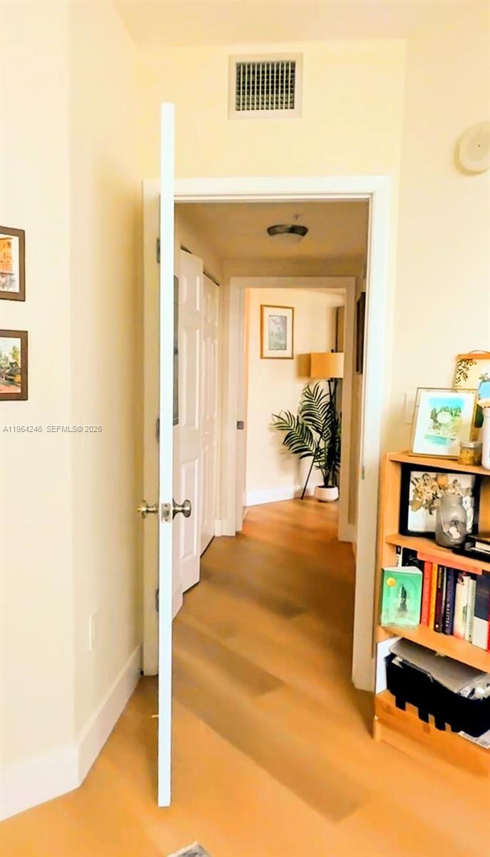 A view through an open doorway into a hallway with light wood flooring — 2000 N Bayshore Dr # 801, Miami FL 33137, MIAMI, FL