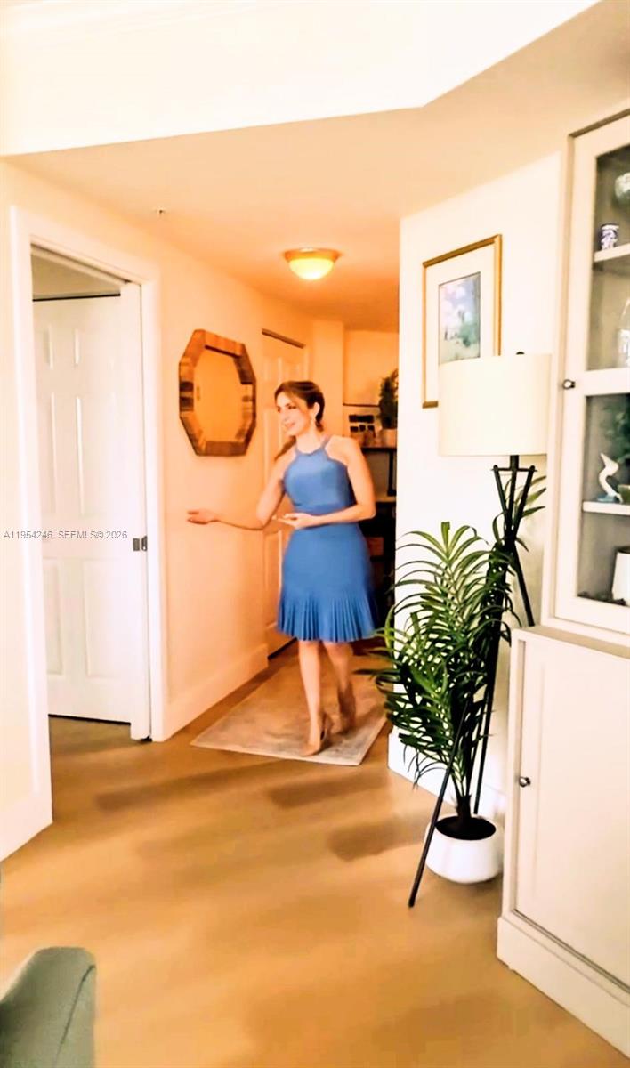 A woman in a blue dress stands in a hallway with light-colored flooring — 2000 N Bayshore Dr # 801, Miami FL 33137, MIAMI, FL