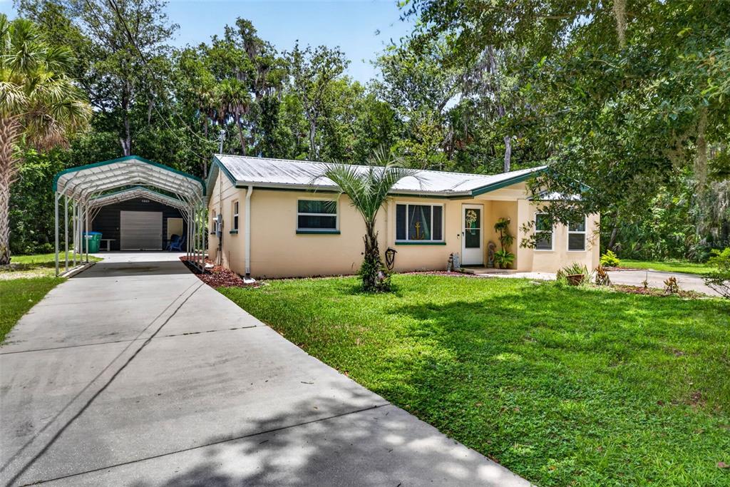 A single-story house with a metal roof, a concrete driveway, and a detached metal carport — 5304 S JAMES TERRACE, HOMOSASSA, FL