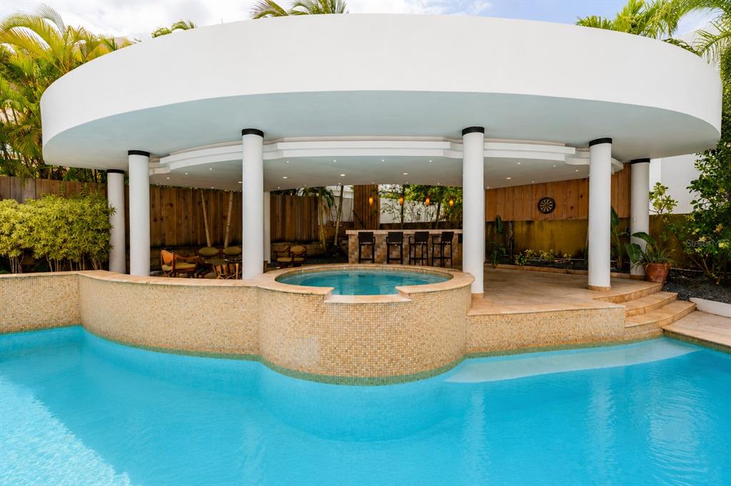 A swimming pool with an integrated hot tub sits beneath a large, circular covered patio — 16 CALLE PALMA DE COCO, DORADO, PR
