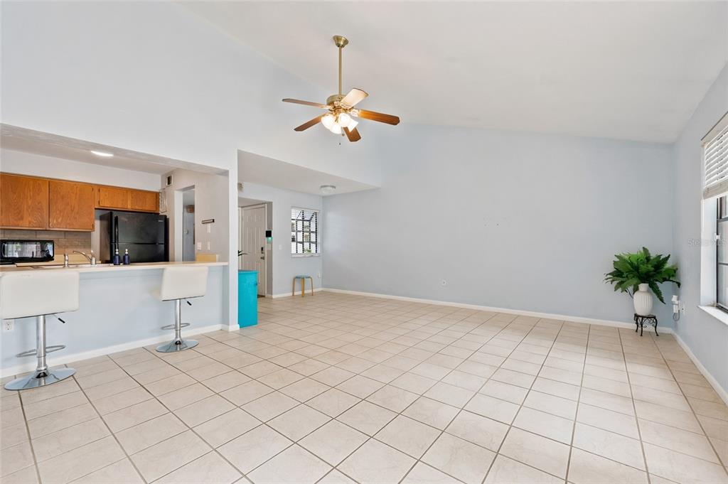 An open-concept living area features light blue walls, beige tile flooring, and a ceiling fan — 4431 SW 21ST LANE, GAINESVILLE, FL