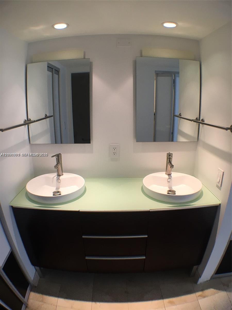 A bathroom features a double vanity with white vessel sinks and a glass countertop — 11 Island Ave # 1505, Miami Beach FL 33139, MIAMI BEACH, FL