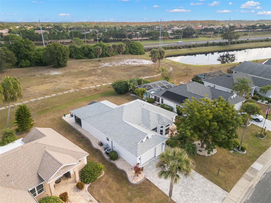 An aerial view shows a suburban house with a gray roof and a paved driveway — 1911 E DEL WEBB BOULEVARD, SUN CITY CENTER, FL