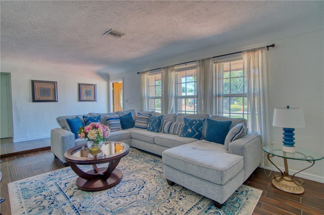 A living room features a large gray sectional sofa, a round coffee table, and area rug — 3513 E Shore Road, Miramar FL 33023, MIRAMAR, FL