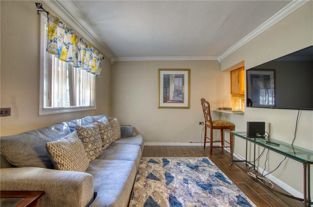 A living room features a gray sofa, a patterned rug, and a wall-mounted television — 3513 E Shore Road, Miramar FL 33023, MIRAMAR, FL
