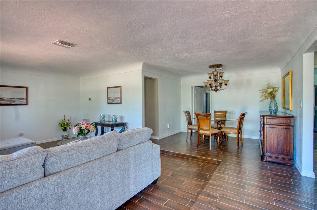 A living room with a gray sofa transitions to a raised dining area with tile floors — 3513 E Shore Road, Miramar FL 33023, MIRAMAR, FL