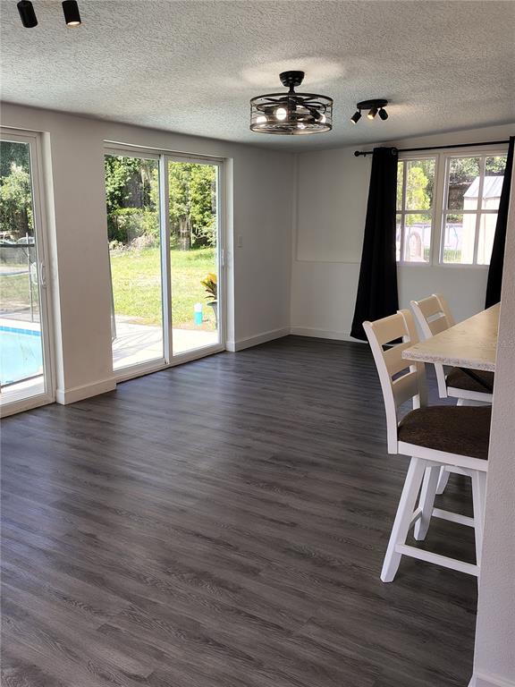 A dining area with gray wood-look flooring, a ceiling fan, and sliding glass patio doors — 415 E BERESFORD AVENUE, DELAND, FL
