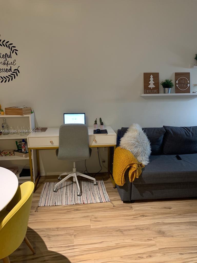 A home office area features a white desk, gray chair, and a sofa against a wall — 951 Brickell Ave # 1503, Miami FL 33131, MIAMI, FL