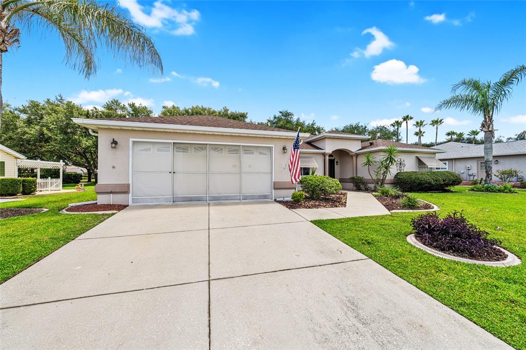 A single-story house with a three-car garage, a concrete driveway, and a front lawn — 9082 SE 135TH LOOP, SUMMERFIELD, FL