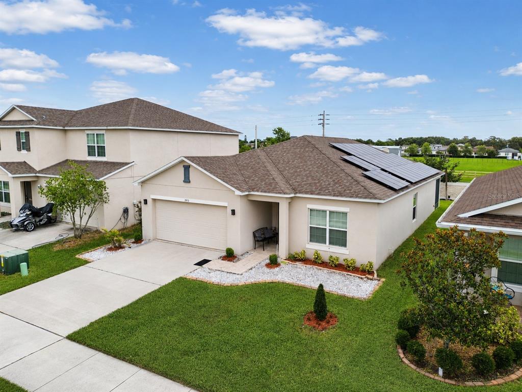 An exterior view of a single-story suburban house with solar panels on the roof — 2975 PARKFIELD ROAD, ST CLOUD, FL