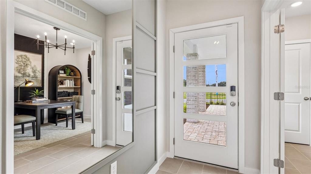 A bright entryway features a white front door, tile flooring, and a view into an office — 428 LIBERTY BEND, HAINES CITY, FL