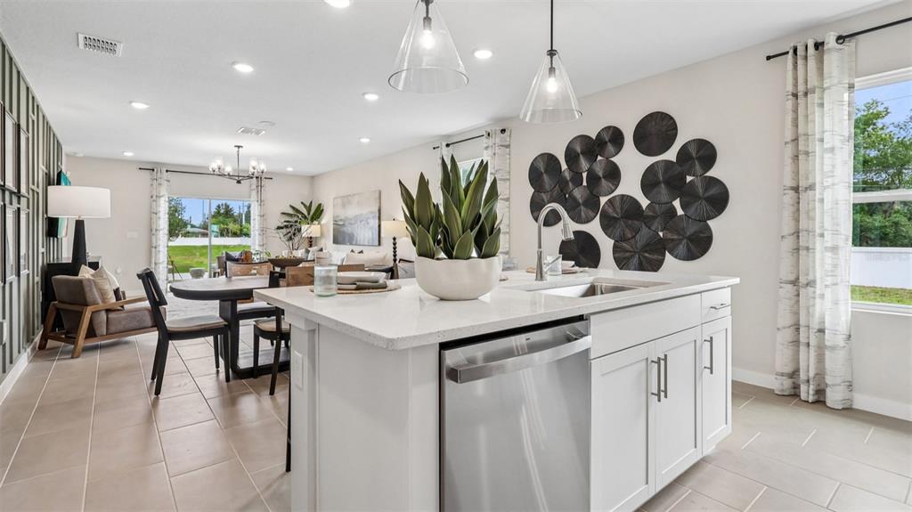 A kitchen island with a stainless steel dishwasher sits in an open-concept living area — 428 LIBERTY BEND, HAINES CITY, FL