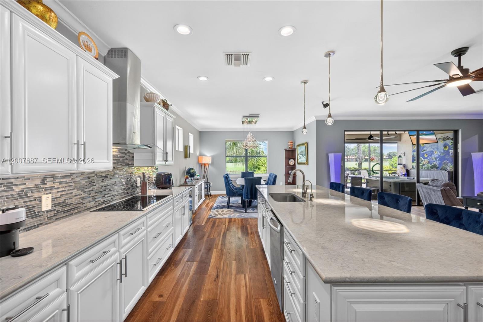A single-story house features a brick driveway, a three-car garage, and a blue front door — 6120 Victory Dr, Ave Maria FL 34142, AVE MARIA, FL