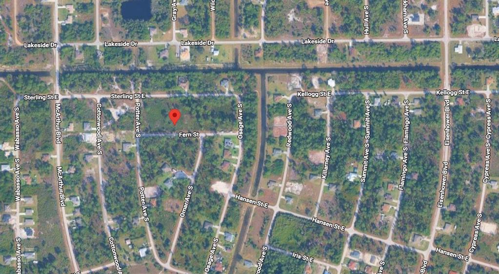 This is an aerial map view of a residential neighborhood with streets and vacant lots — 933 FERN STREET E, LEHIGH ACRES, FL