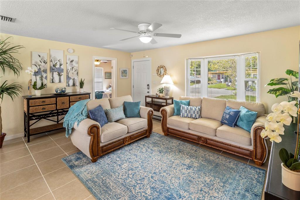 A living room features two beige sofas, a blue area rug, and a ceiling fan — 2865 POPLAR STREET, SARASOTA, FL