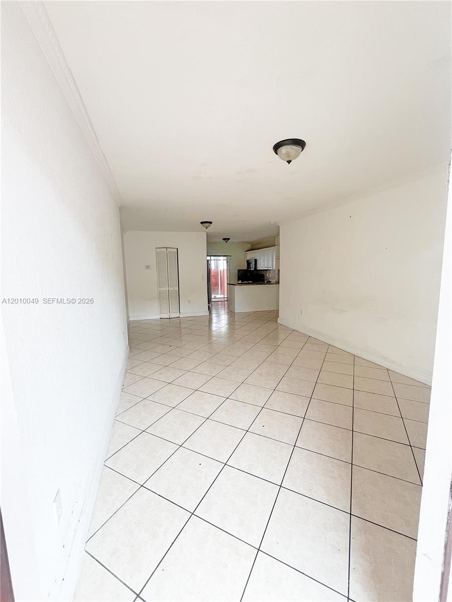 This room features light-colored tile flooring, white walls, and a view toward the kitchen — 11051 W Okeechobee Rd # 101, Miami FL 33018, MIAMI, FL