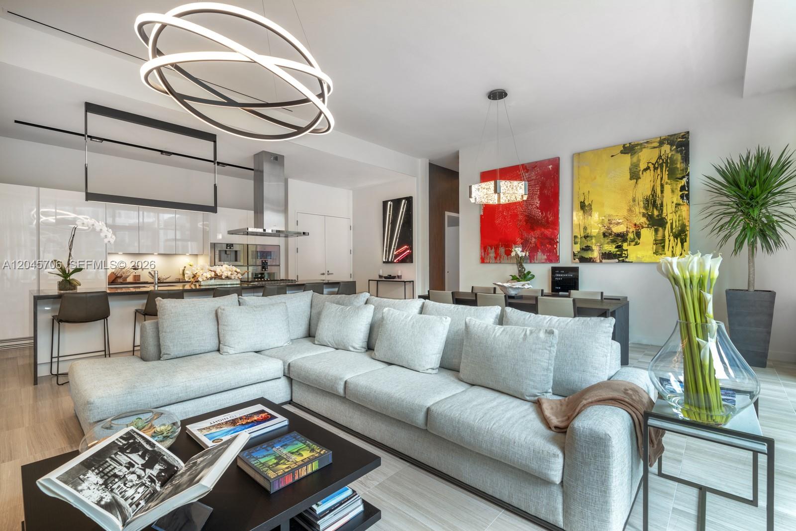 A modern open-concept living room features a large gray sectional sofa and a kitchen island — 4701 N Meridian Ave # 209, Miami Beach FL 33140, MIAMI BEACH, FL