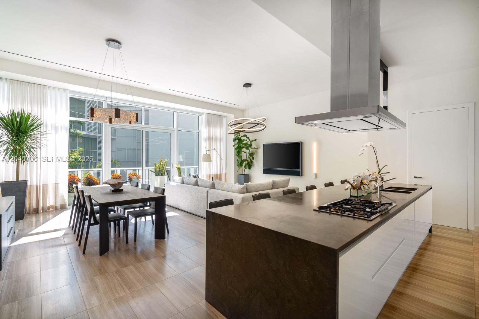 A modern open-concept living area features a kitchen island, dining table, and floor-to-ceiling windows — 4701 N Meridian Ave # 209, Miami Beach FL 33140, MIAMI BEACH, FL