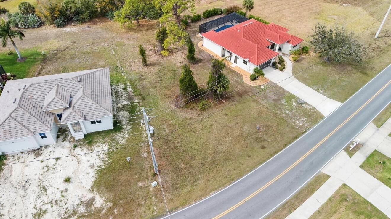 An aerial view shows two houses with tiled roofs situated on a grassy, suburban lot — 4270 Cape Haze Dr Drive, FL 33946, FL
