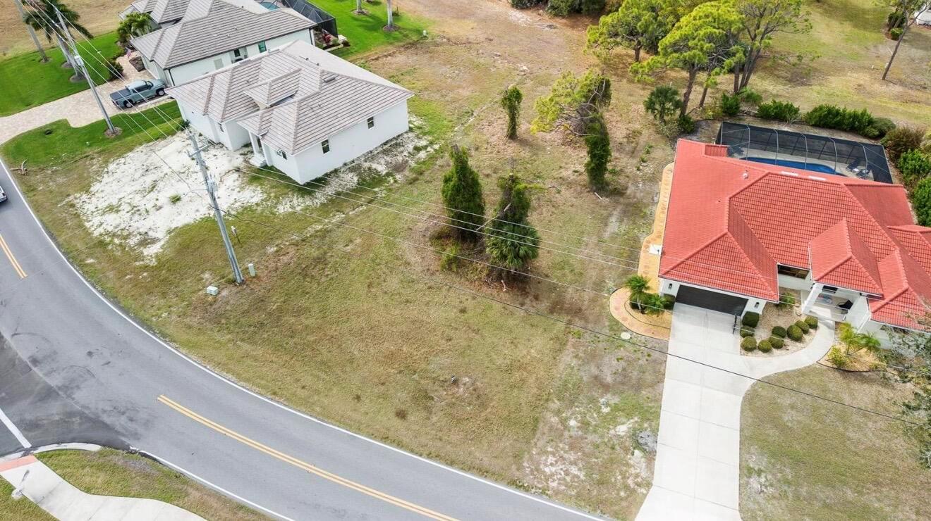 An aerial view shows two houses separated by a vacant lot with power lines — 4270 Cape Haze Dr Drive, FL 33946, FL
