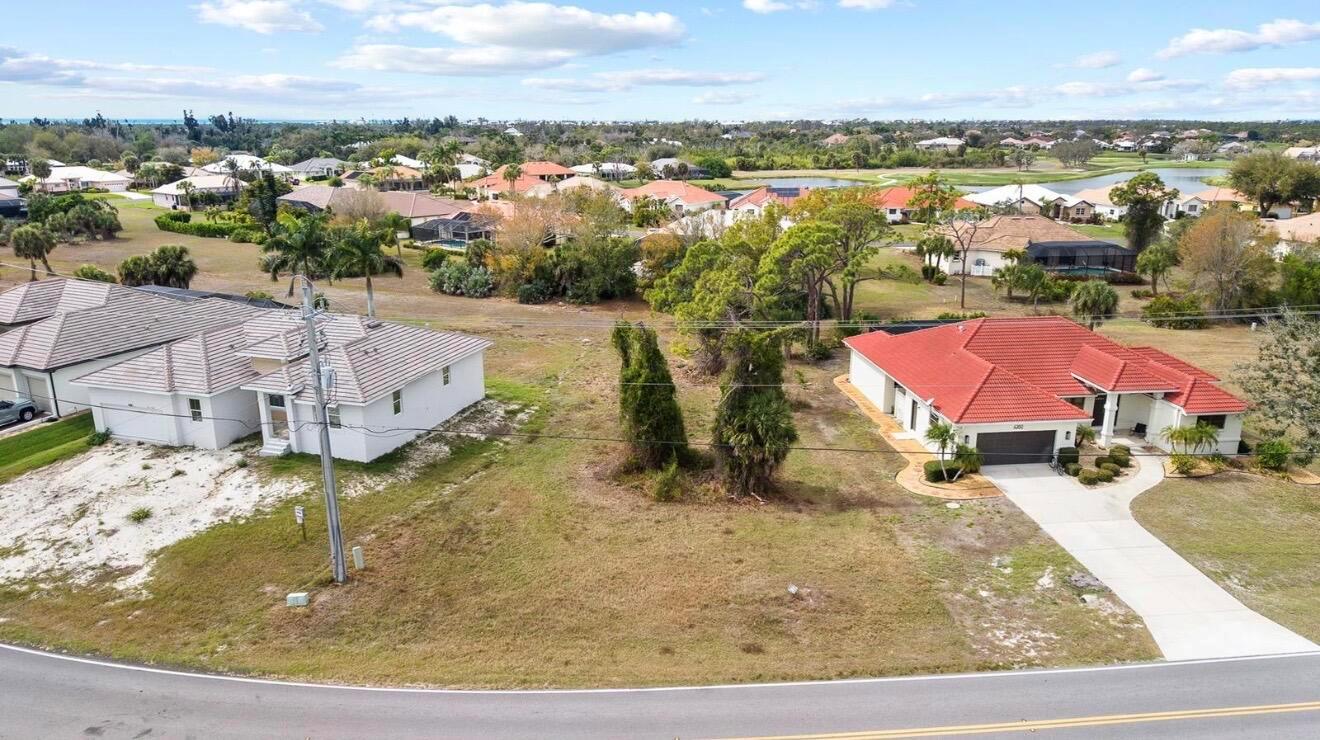 An aerial view shows a vacant residential lot situated between two single-family homes — 4270 Cape Haze Dr Drive, FL 33946, FL