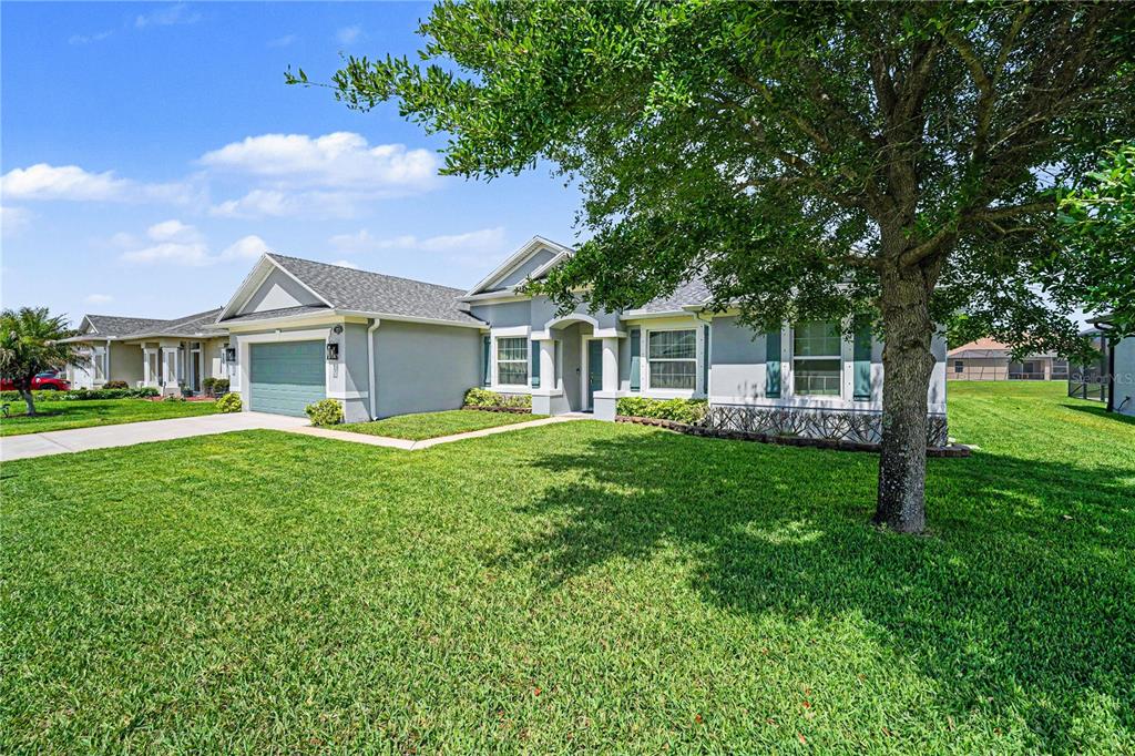 A single-story house with a gray exterior, a two-car garage, and a large front lawn — 1025 MORGAN CIRCLE NE, PALM BAY, FL