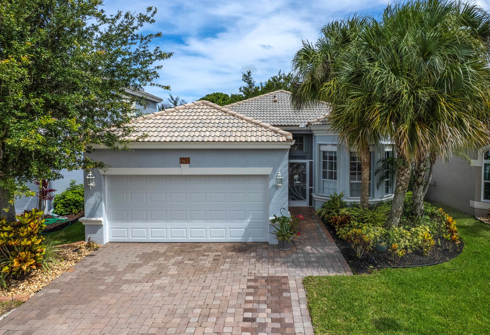 A single-story house with a tiled roof, a two-car garage, and a brick paver driveway — 3785 NW Deer Oak Drive, Jensen Beach FL 34957, JENSEN BEACH, FL