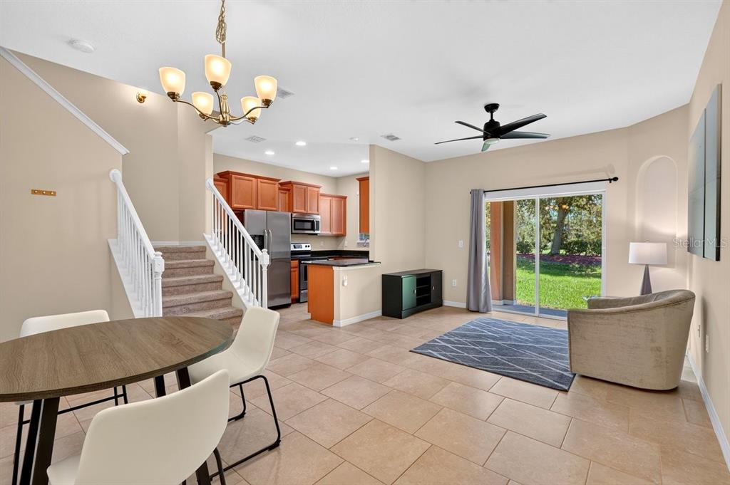 An open-concept living and dining area features tile floors, a staircase, and a kitchen — 205 WENTWORTH GRANDE DRIVE, DAYTONA BEACH, FL