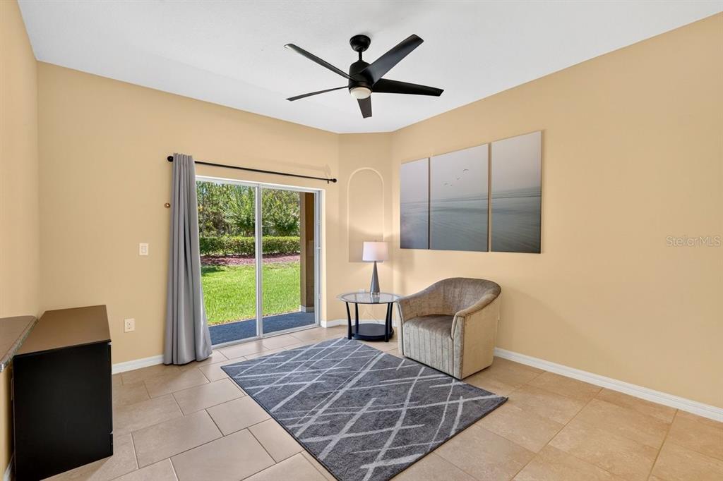 A living area features tile flooring, a ceiling fan, a sliding glass door, and furniture — 205 WENTWORTH GRANDE DRIVE, DAYTONA BEACH, FL