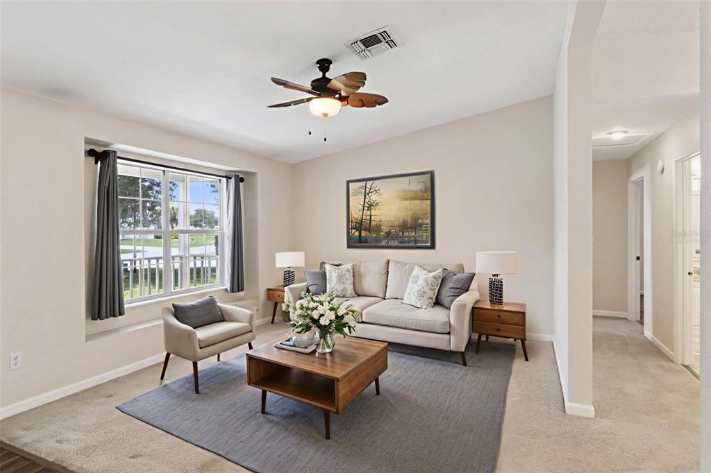 A living room features a beige sofa, a wooden coffee table, and a ceiling fan — 3829 SPRINGLAKE VILLAGE COURT, KISSIMMEE, FL