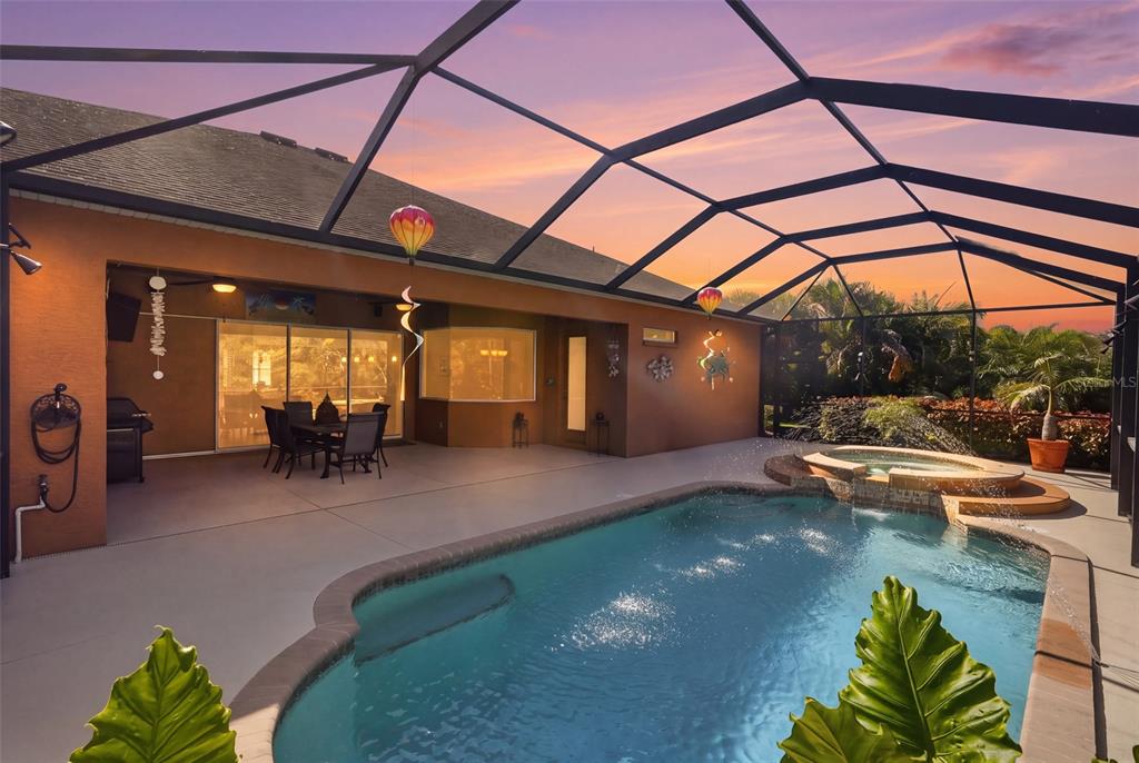 A screened-in patio features a swimming pool, a raised spa, and a dining area — 12619 50TH COURT E, PARRISH, FL