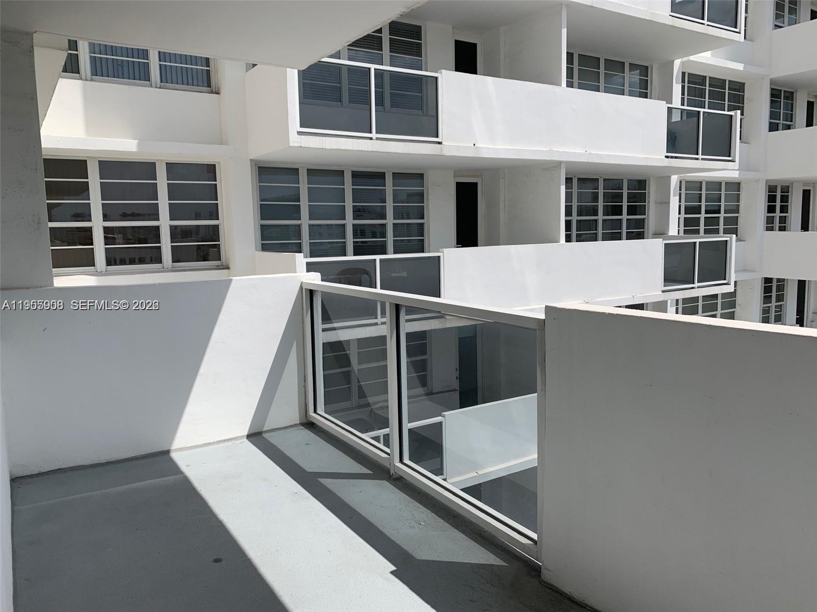 A view from a white balcony looking toward the exterior of a multi-story apartment building — 100 Lincoln Rd # 903, Miami Beach FL 33139, MIAMI BEACH, FL